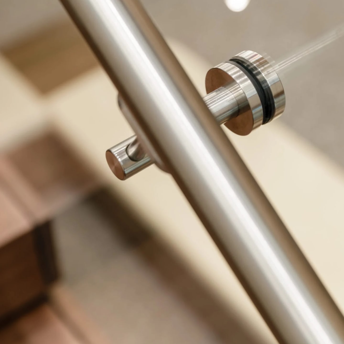Angled close view of the stainless handrail and its round glass clamp