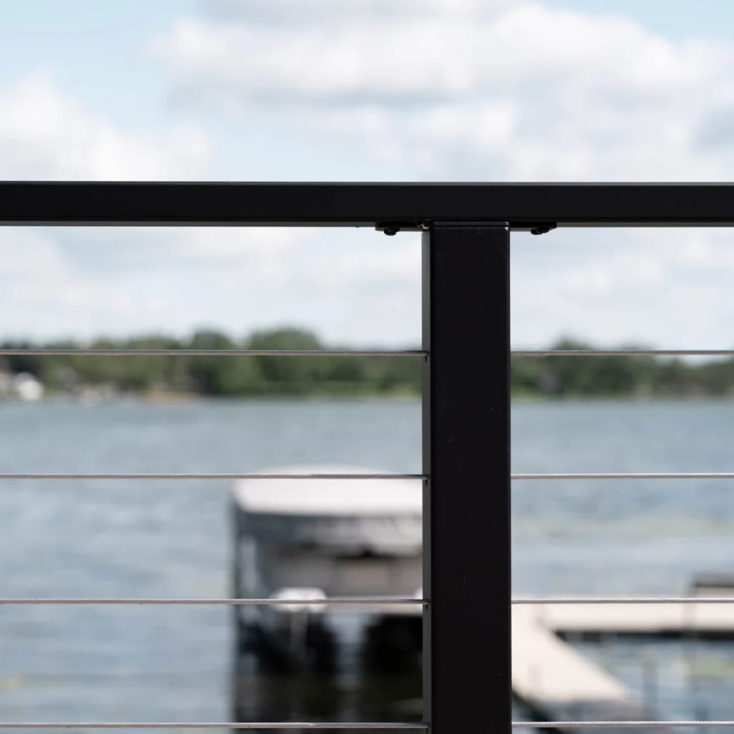 Lake and boat dock framed between the top rail and cable lines