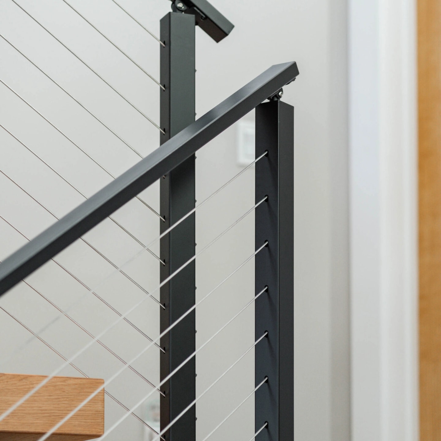 Two railing sections meeting at a corner post next to a wood door frame