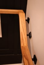 Close view of an ash wall handrail on black square brackets