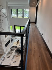 Black cable railing with dark wood handrail