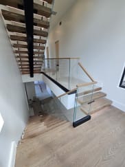 Reclaimed-wood floating treads on a mono stringer with Vedera glass and a base rail glass landing with wood cap