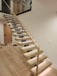 White oak floating stair with LED lighting and glass railing with wood handrail
