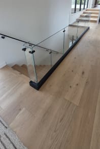 Frameless base rail glass at the top of an oak stair