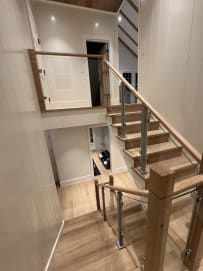 Oak stair with glass panels on aluminum posts and wood newels rising through two floors