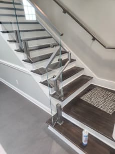 Stainless post glass railing and a curved stainless wall handrail at a commercial stair landing