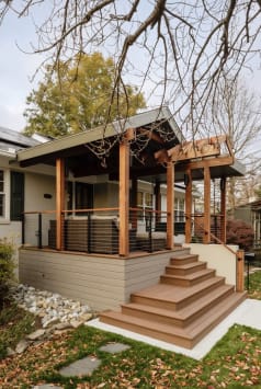 Cedar-post covered porch with cable railing and wide composite steps on a craftsman home.
