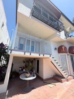 Frameless glass with burnished bronze standoff pins along exterior stucco steps and a balcony.