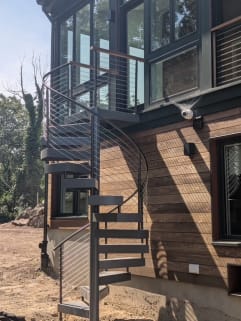Exterior spiral stair with curved cable railing