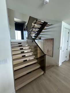 White oak FLIGHT Mono switchback with smoked glass railing and black top cap