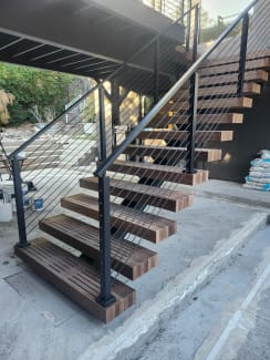 Exterior floating stair with black cable railing