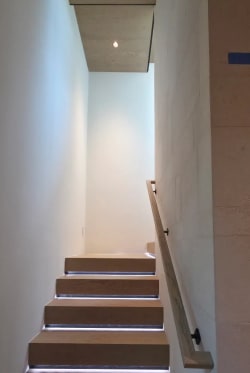 Straight run of oak treads with LED strip lighting and a wood wall handrail