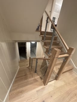 Glass railing on aluminum posts with chunky oak newels and handrail on a turning oak stair
