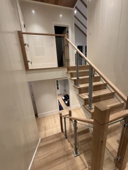 Oak stair with glass panels on aluminum posts and wood newels rising through two floors
