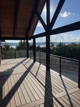 Black-post glass railing on a timber-framed deck with a sweeping lake view