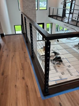 Black cable railing with dark wood handrail