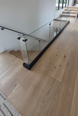 Frameless base rail glass at the top of an oak stair