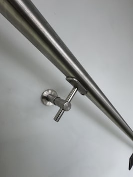 Close-up of a round stainless steel handrail on a wall bracket
