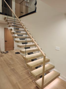 White oak floating stair with LED lighting and glass railing with wood handrail