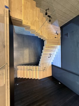 White oak switchback Stack stair with glowing LED treads and frameless glass
