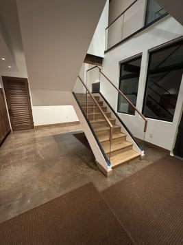 White oak stair with frameless base rail glass and walnut handrails in a mudroom entry