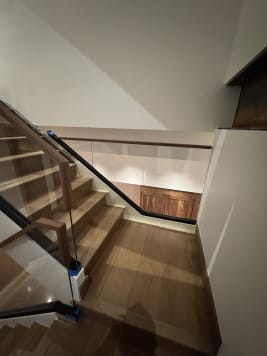 Frameless base rail glass and walnut handrail turning at a white oak stair landing