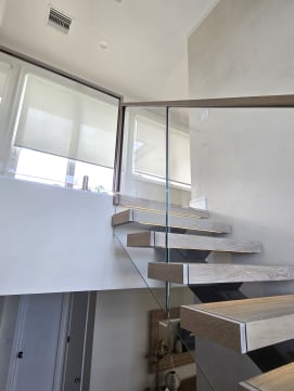 Gray-washed oak floating treads on a mono stringer with LED-lit nosings