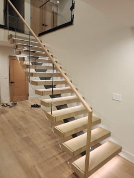 White oak floating stair with LED lighting and glass railing with wood handrail