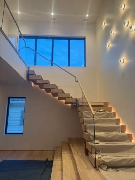 White oak Stack stair with connected boxy treads, LED underlighting and frameless glass with wood cap