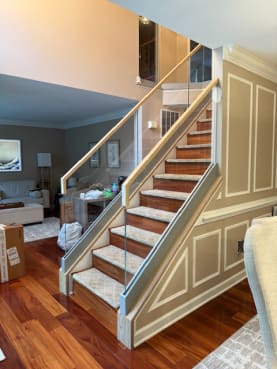 Base rail glass with an oak top cap along a traditional stair