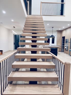 Head-on view of a straight white oak FLIGHT Mono stair rising to a loft