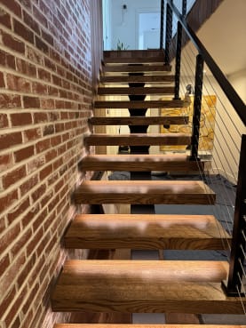 FLIGHT Mono stair along brick wall with cable railing