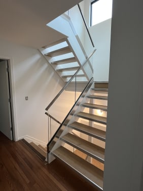 Open-riser oak stair on stainless stringers with frameless glass and stainless cap