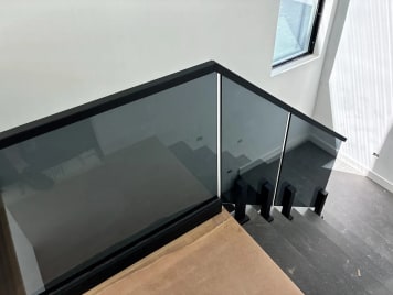 Tinted glass stair guard with black cap