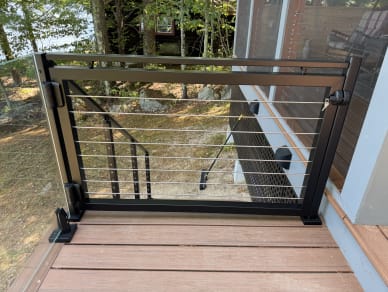 Jet black gate with rod infill between talon-mounted glass and cable stair railing