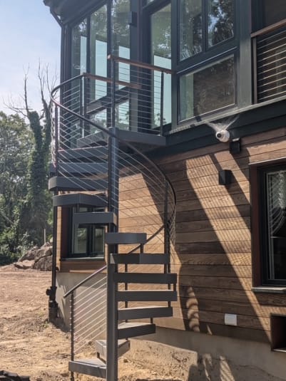 Exterior spiral stair with curved cable railing