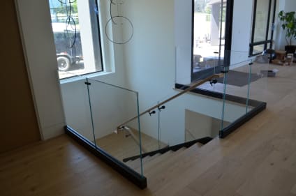 Glass stairwell guard with black base rail