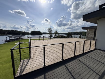 Surface-mount Onyx rod railing edges a deck overlooking a lake, dock and boathouse