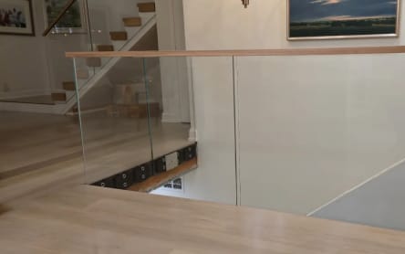 Glass stairwell guard with oak cap
