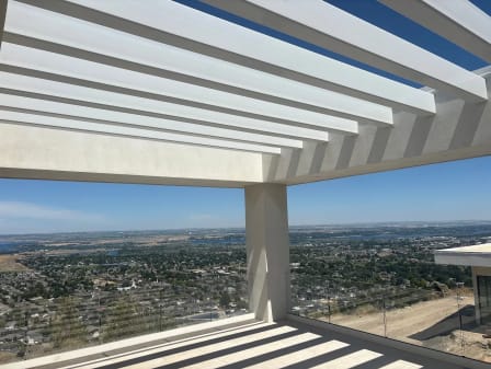 Pergola terrace with glass railing overlooking a valley