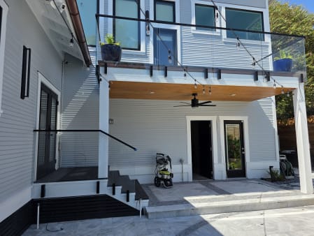 Frameless glass on side-mount talons along an upper balcony and steps of a modern pool house