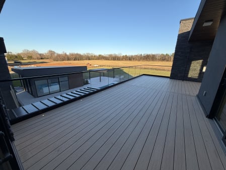 Base rail glass with a black cap edges a composite terrace overlooking open fields