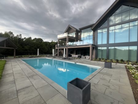 Pool terrace with glass balconies on the home behind