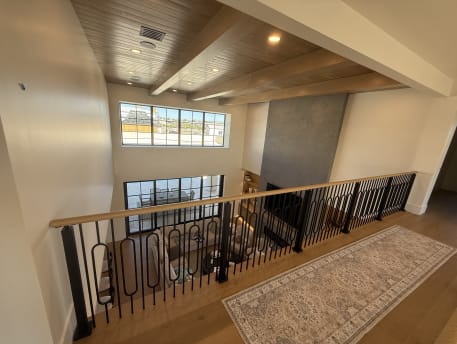 Black decorative balusters with an oak handrail along a loft overlooking a great room