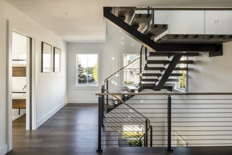 Black FLIGHT Mono with dark treads and horizontal cable railing spans a bright upstairs hall.