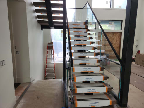 Floating stair in clean Viewrail covers with frameless glass and black top cap