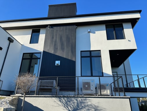 Cable railing runs along a terrace and exterior stair of a white modern home.