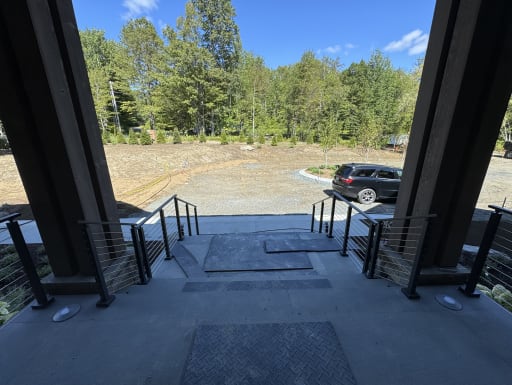 Cable railing on a porch facing a gravel drive