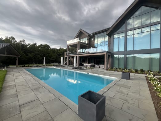 Pool terrace with glass balconies on the home behind