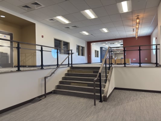 Black-post glass railing and handrails around a commercial stair and mezzanine